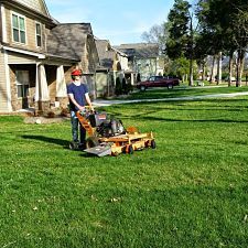 A picture of a man standing on a lawn mower showcasing the landscaping Chattanooga services by Ray Lawns.
