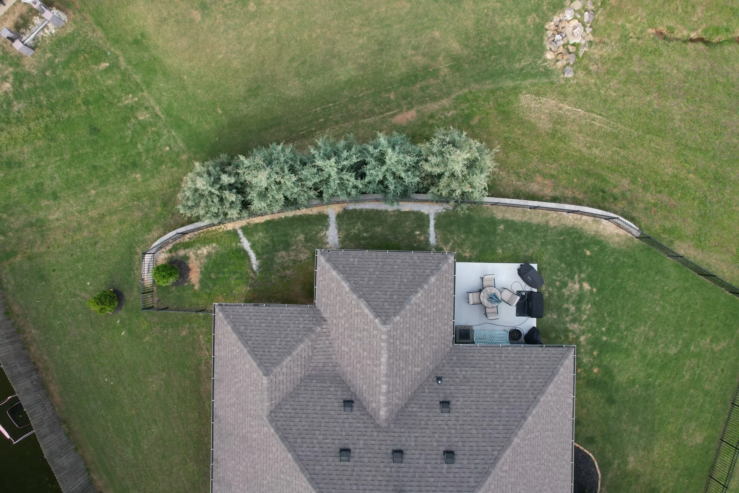 This overhead view shows how the privacy trees follow the curve of the retaining wall and help frame the backyard.